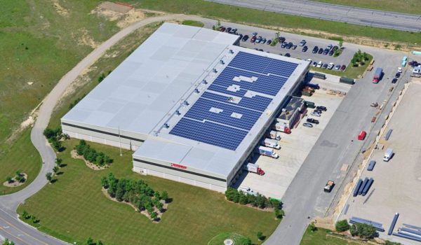 Aerial view of a rooftop commercial solar installation on a warehouse