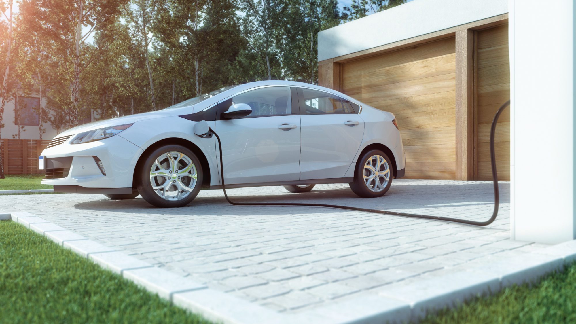 A white electric vehicle is being charged at a home charging station.